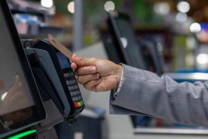 wizytowka-kasoterminal osoba płacąca przy aksoterminalu